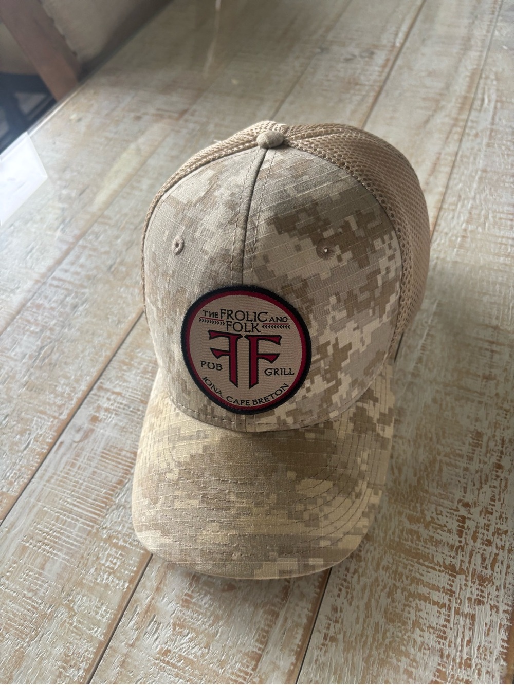 The Frolic and Folk Pub & Grill Camo Mesh Trucker Hat - Tan